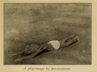 This devout man is traveling a great distance to a holy shrine by prostrating himself, rising, and then prostrating himself again.